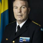 Thomas Nilsson i uniform vid en svensk flagga